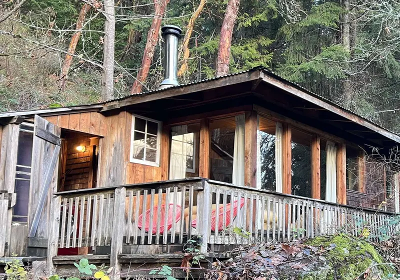 The cabin tucked into the forest on its rock outcrop